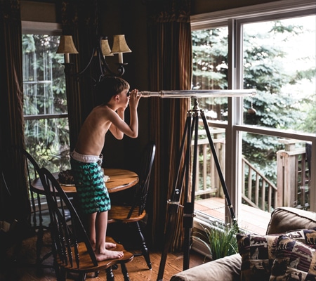Petit garçon qui regarde à travers un téléscope